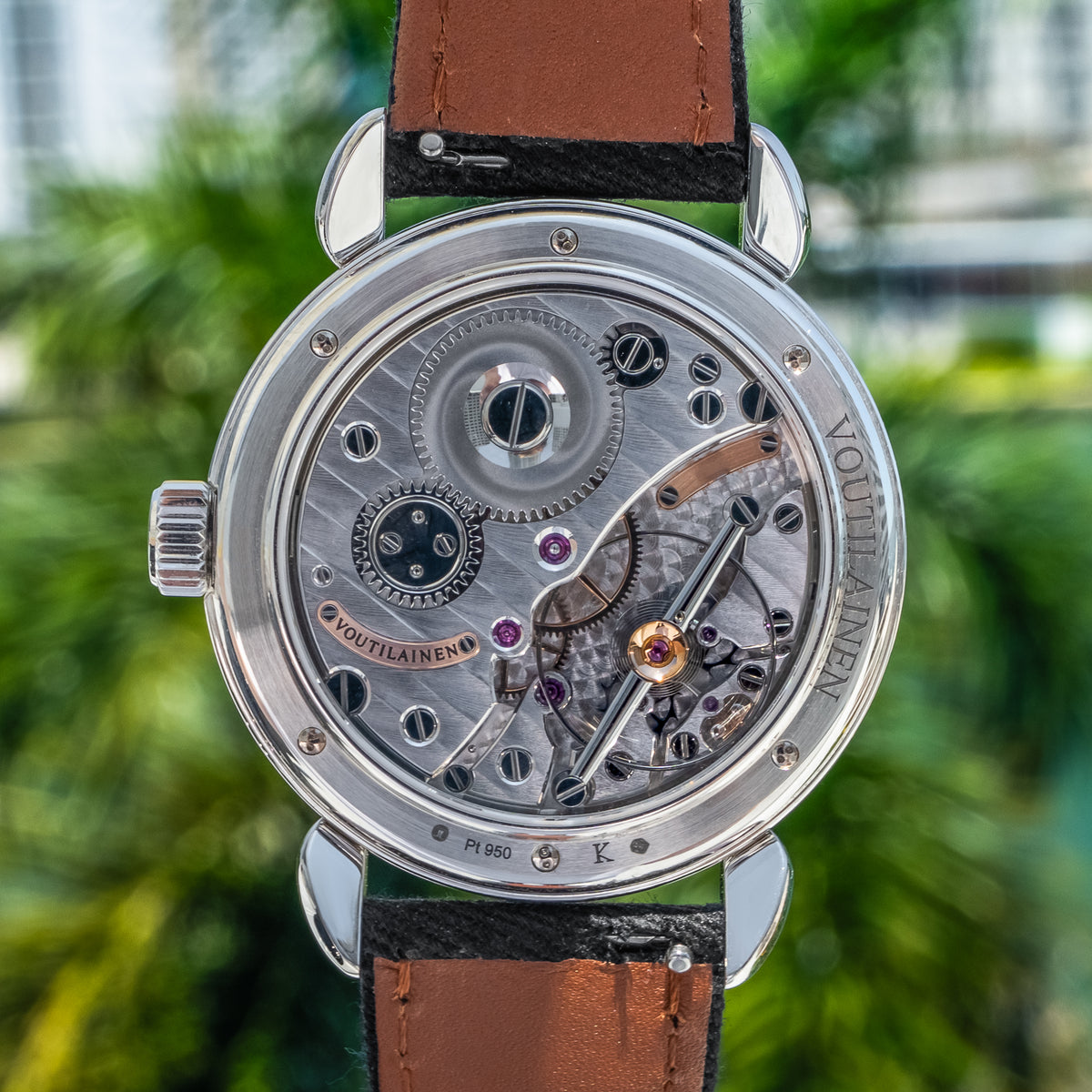 Hand-finished Kari Voutilainen movement seen through the sapphire caseback